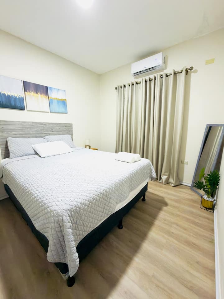 房间# 2标准双人床、镜子、衬里窗帘、空调和篮子。