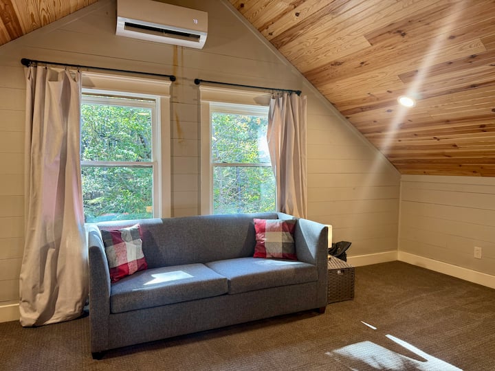 Sofá cama en el loft, que ofrece un lugar cómodo para que los huéspedes adicionales duerman o descansen mientras disfrutan del divertido espacio abierto del loft.