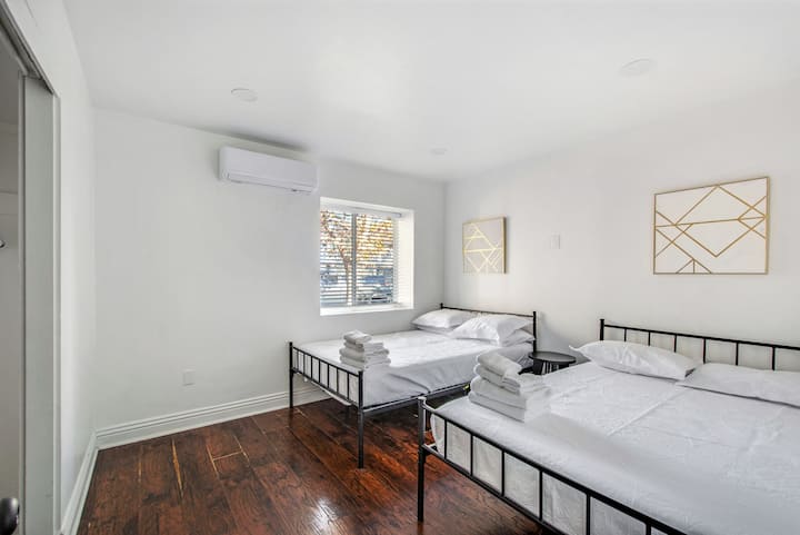 Habitación doble luminosa con muebles modernos y sábanas blancas nuevas.