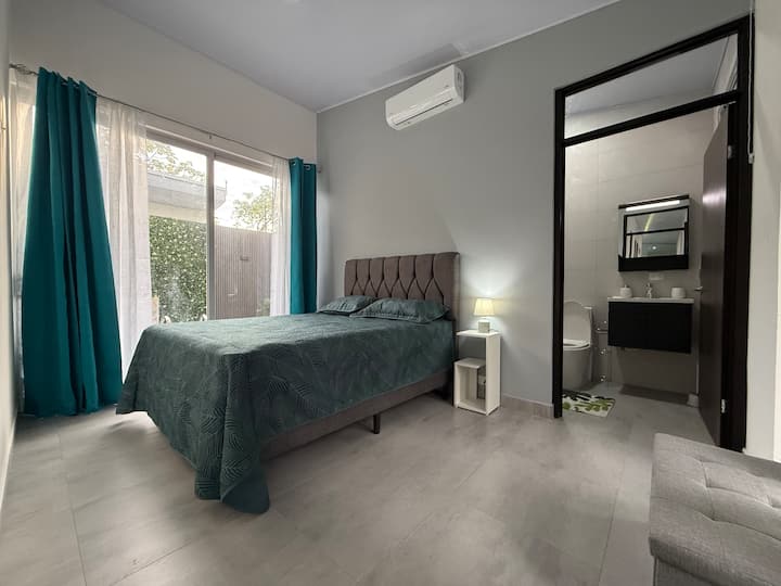 Hoofdslaapkamer met queensize bed en eigen badkamer. Het heeft toegang tot het zwembad en airconditioning inbegrepen.