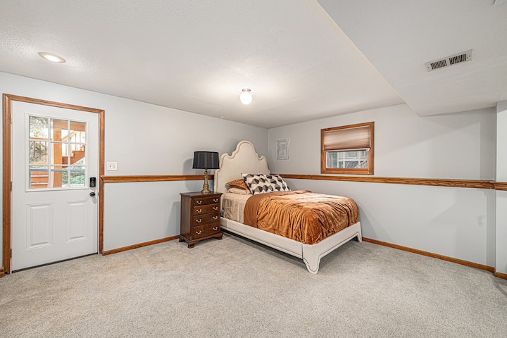 A bright and spacious bedroom with soft carpet, clean finishes, and a cozy bed setup that creates a calm and relaxing atmosphere.