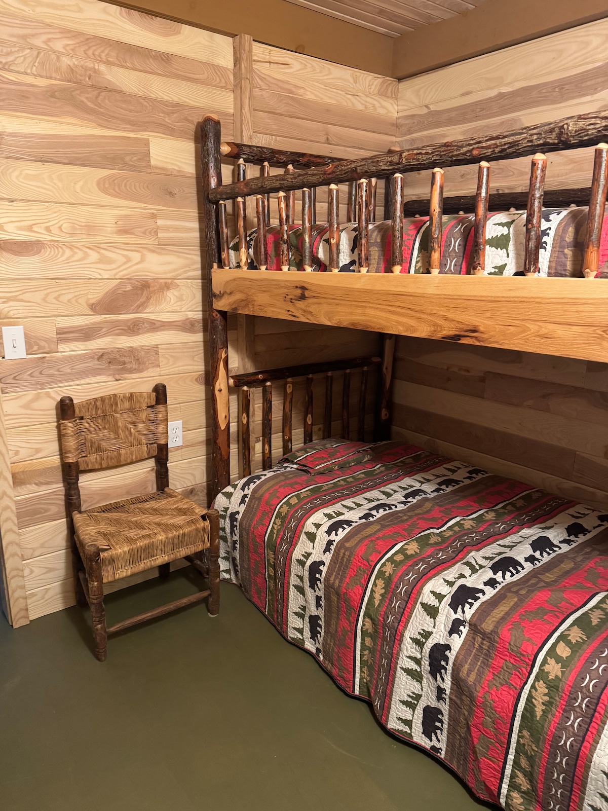 Inviting second bedroom with a comfortable bunk bed, warm wood textures, and simple, clean décor. Ideal for families or friends looking to enjoy a quiet getaway on a spacious 30-acre property with its own waterfall.