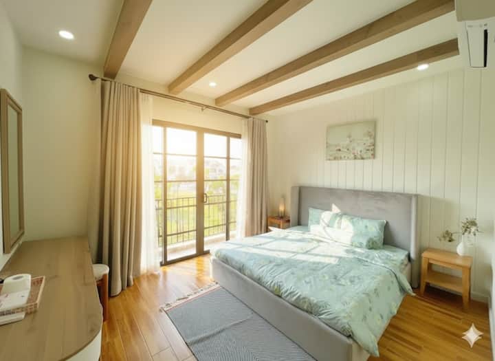 Chumba cha kulala cha Moon Villa ni tulivu, kimejaa mwanga wa asili kutoka kwenye mlango mkubwa wa kioo unaofunguka kuelekea kwenye roshani ya kijani kibichi. Mapambo ya kupendeza yenye kitanda laini, dari ya mbao yenye joto na rangi laini, yanayotoa hisia ya kupumzika kabisa, faragha na starehe kwa ajili ya usingizi kamili.