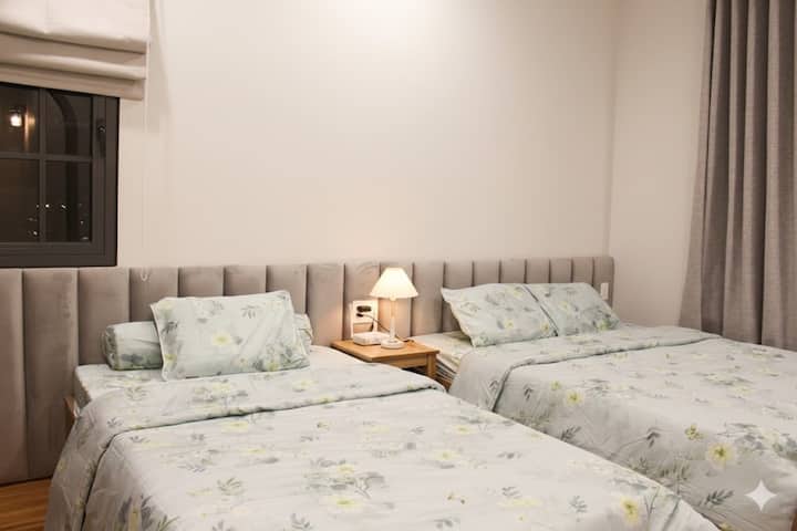 Chumba cha kulala cha Moon Villa kina vitanda viwili laini, mashuka laini na taa za manjano zenye kupendeza. Sehemu tulivu, nadhifu iliyo na samani chache, inayofaa kwa familia au makundi ya marafiki kupumzika kwa starehe baada ya siku ya kuvinjari Phan Thiet.