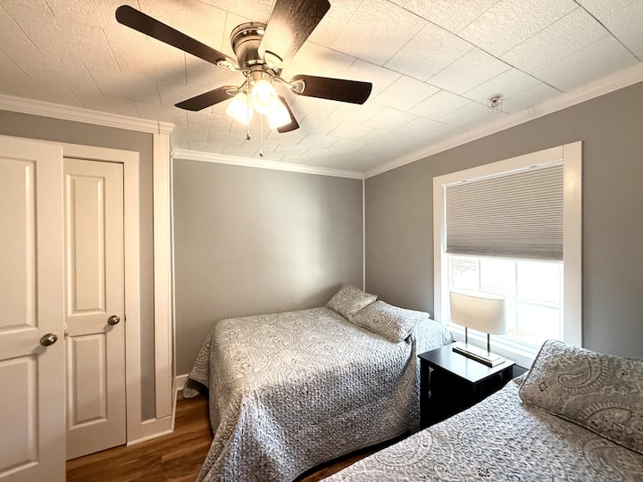 Chambre lumineuse et confortable avec deux lits doubles et une literie douce, idéale pour les voyageurs supplémentaires.