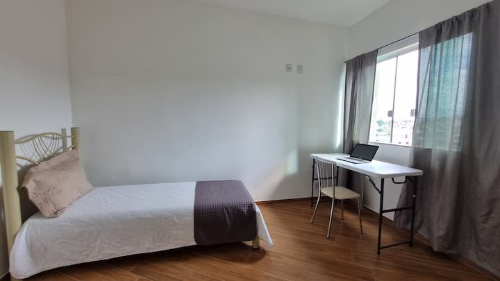 მყუდრო საძინებელი ერთადგილიანი საწოლით, სამუშაო ადგილითა და ფანჯრით, რომელიც შესანიშნავ განათებასა და ბუნებრივ ვენტილაციას უზრუნველყოფს. მშვიდი და ფუნქციური საცხოვრებელი, რომელიც იდეალურია დასასვენებლად ან კომფორტულად მუშაობისთვის.