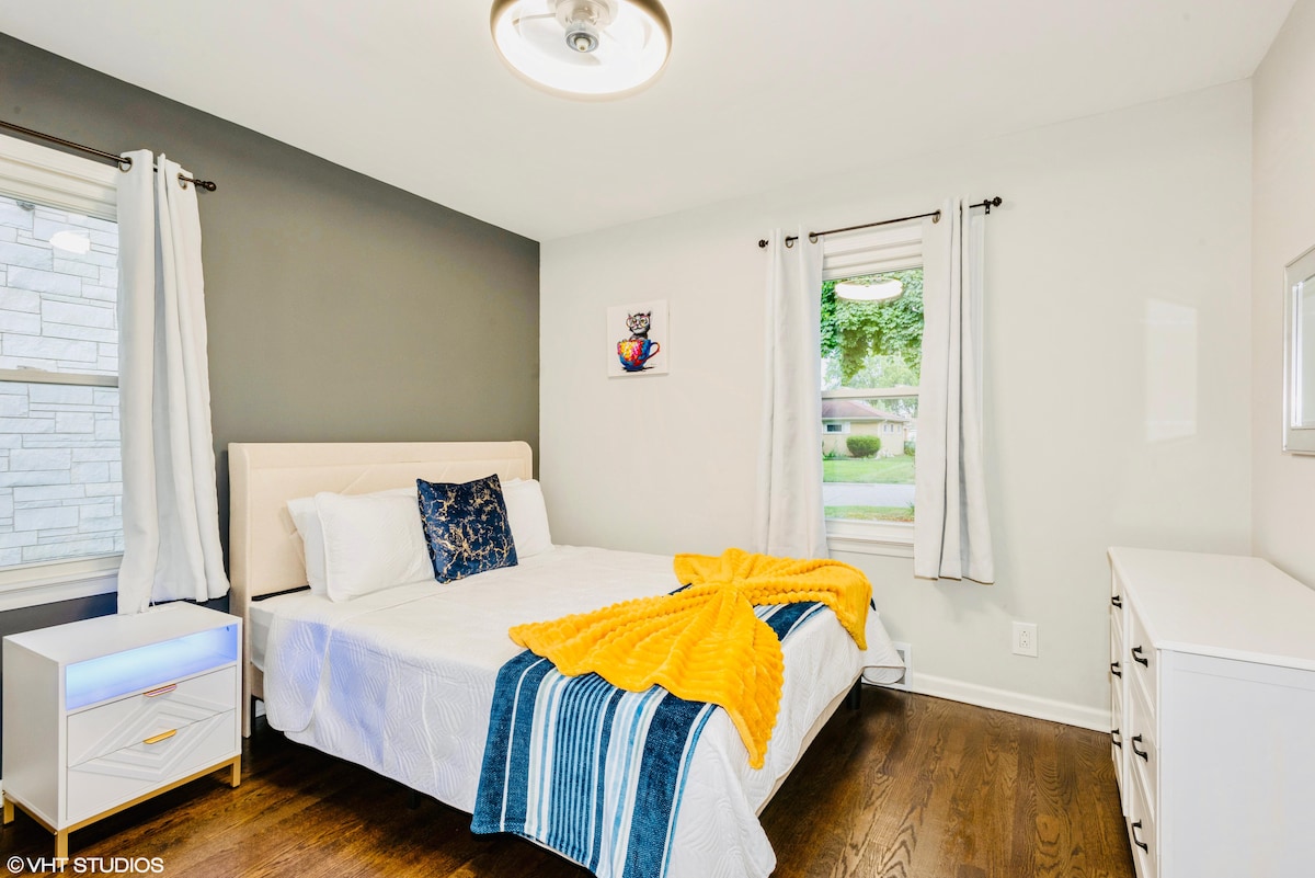 Cama tamaño queen con un colchón suave medio, vestidor, mesita de noche, armario y televisor Roku. 