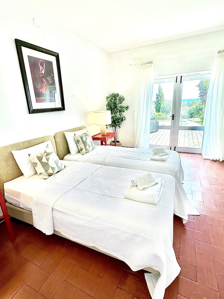 Bedroom 1 is in the main house with twin beds and ensuite bathroom.  Shower over bath.  The doors open up onto the upper terrace with lovely views of the ocean and town beyond.