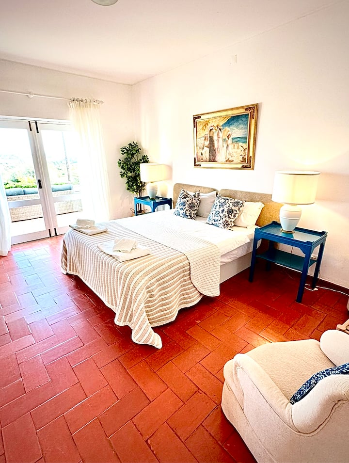 Bedroom 2 is in the main house with king bed, and its own ensuite bathroom with a shower over the bath.  Doors lead onto the upper terrace with views over the ocean and town beyond.