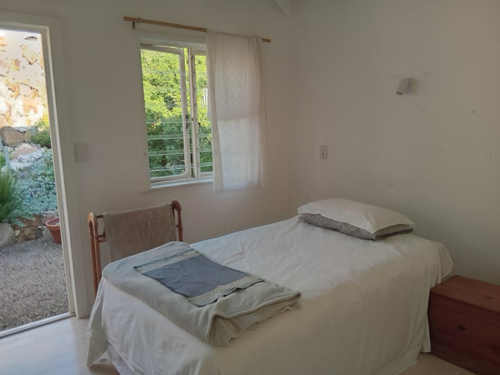 dormitorio pequeño con una cama de tamaño 3/4 en suite, que se abre a un pequeño patio 