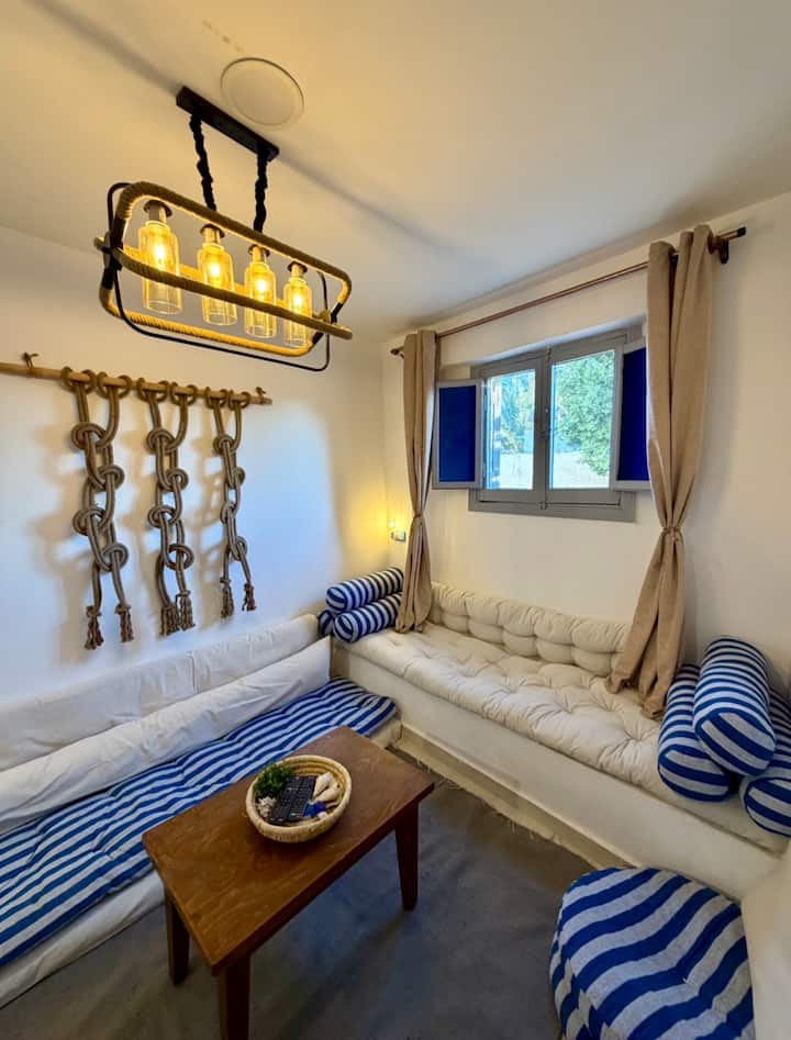 Obývacia izba v štýle námornej bohémskej elegancie v ubytovaní Cozy Cushion Cove – dokonalá centrálna základňa pre váš výlet do Dahabu. Vankúše a pohodlie