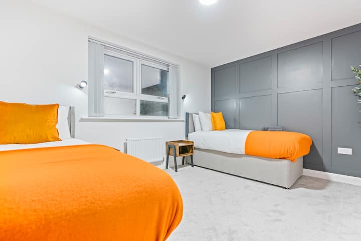 2. spavaća soba:
Moderna dvokrevetna soba s dva udobna kreveta za jednu osobu, nježnim osvjetljenjem i zidom u umirujućoj sivoj boji. Idealno za opuštajući san.