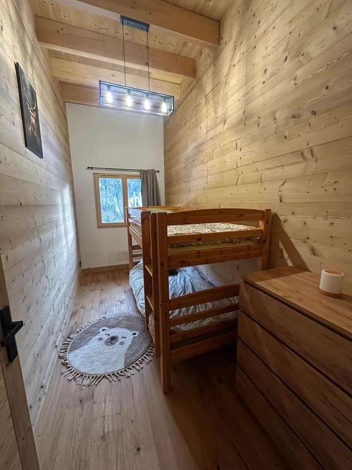 חדר ילדים נעים, עם מיטת קומותיים ואווירה חמה.