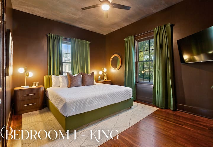 Chumba cha kulala cha 1 kina mapazia ya kijani kibichi, matandiko laini na mbao za joto kwa ajili ya mapumziko ya utulivu.
