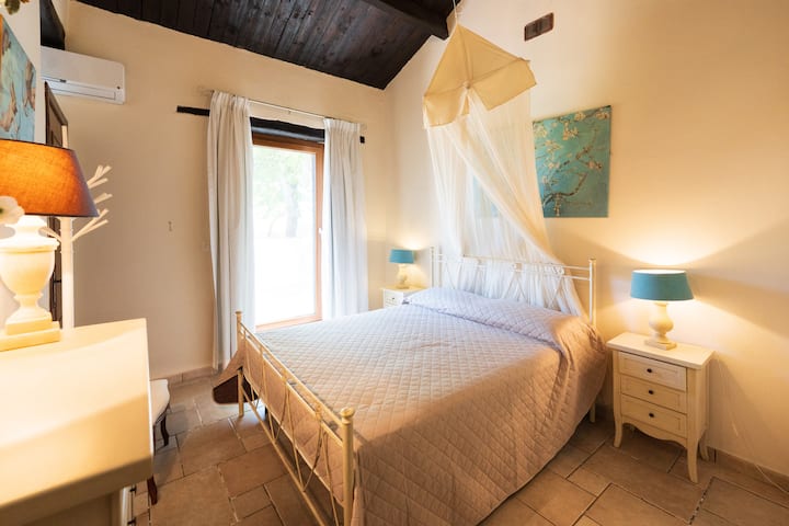 Amplia recámara en el lado izquierdo de la casa, con cama matrimonial, aire acondicionado y acceso directo al exterior.