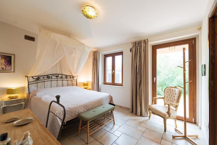 Amplia recámara principal a la derecha de la casa, con cama matrimonial, aire acondicionado, baño privado y acceso directo al exterior.