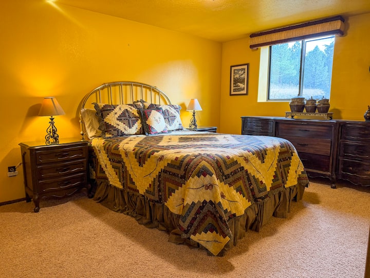 The downstairs bedroom is crafted for supreme comfort, featuring a queen-size bed adorned with plush bedding, fostering a cozy and welcoming atmosphere ideal for rejuvenating before your next day's adventures. 