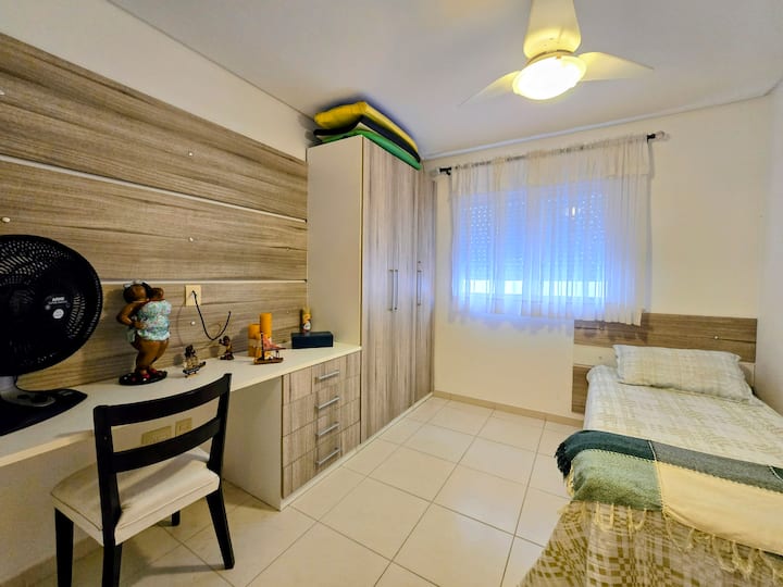 Një hapësirë e ndriçuar dhe e qetë, me dritë të butë që hyn nga dritarja. Krevat të mirëpret me rehati, ndërsa tavolina të mbështet për të punuar ose lexuar në qetësi. Çdo gjë këtu të fton të ngadalësosh ritmin dhe të pushosh mirë.