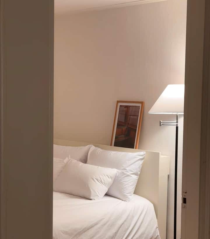 Det andra sovrummet där ljuset stannar tyst bortom dörren.
Om du lutar dig mot en fluffig kudde och en generös filt kan du lägga ner ditt dagliga liv ett tag och möta fullständig frid.

Varm stativbelysning och målningar som lutar mot väggarna ger lite utrymme och en bit av historien.
I slutet av dagen, njut av din egen tid i en mysig atmosfär.