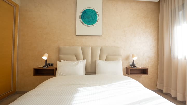 Amplia habitación cálida y elegante que ofrece un ambiente confortable. Los tonos neutros y el acento turquesa crean un ambiente relajante. Grandes ventanas que dejan entrar la luz natural. Detalles cuidados que añaden un toque de estilo. 