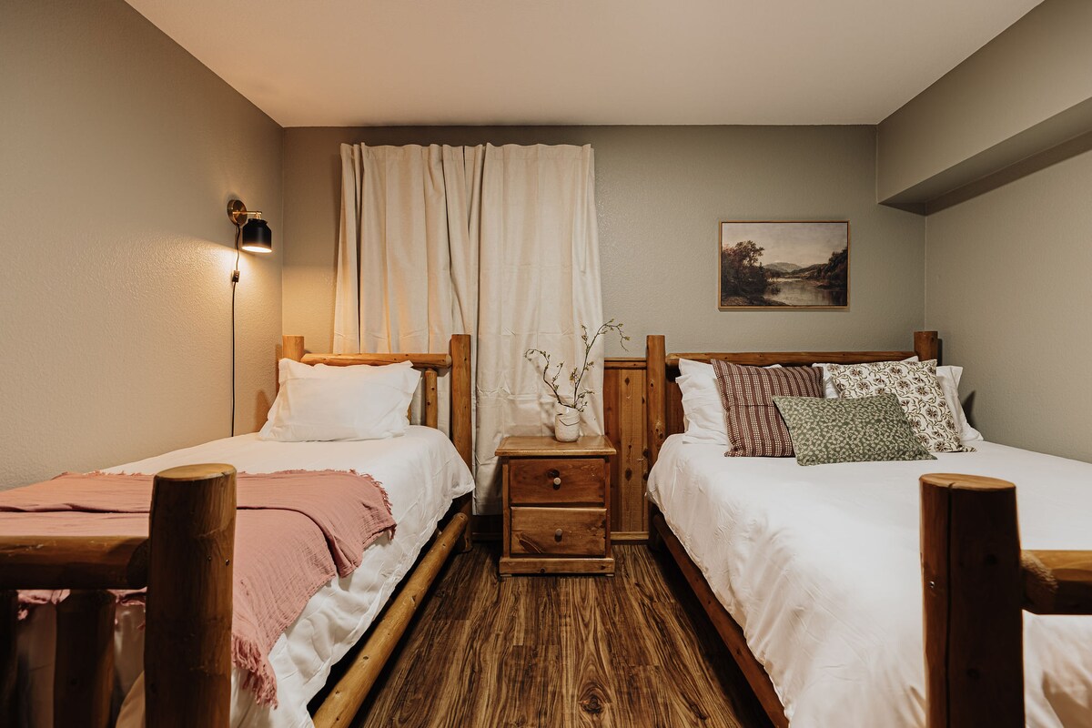 Een gezellige slaapkamer met twee houten bedden en zacht gelaagd beddengoed.