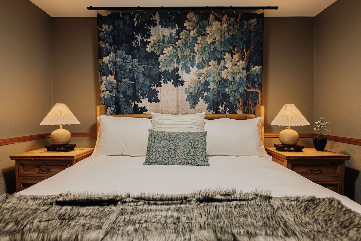 Een gezellige slaapkamer met een zacht bed en een gedurfde, op de natuur geïnspireerde achtergrond.