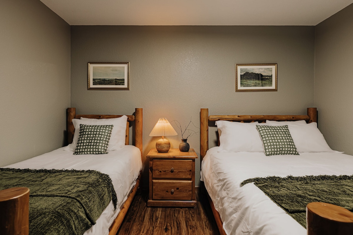 Een gezellige slaapkamer met twee bedden met warme houten frames.