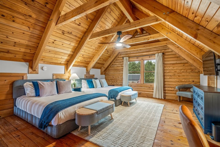 The loft suite with soaring wood ceilings and two queen beds, open to the great room below