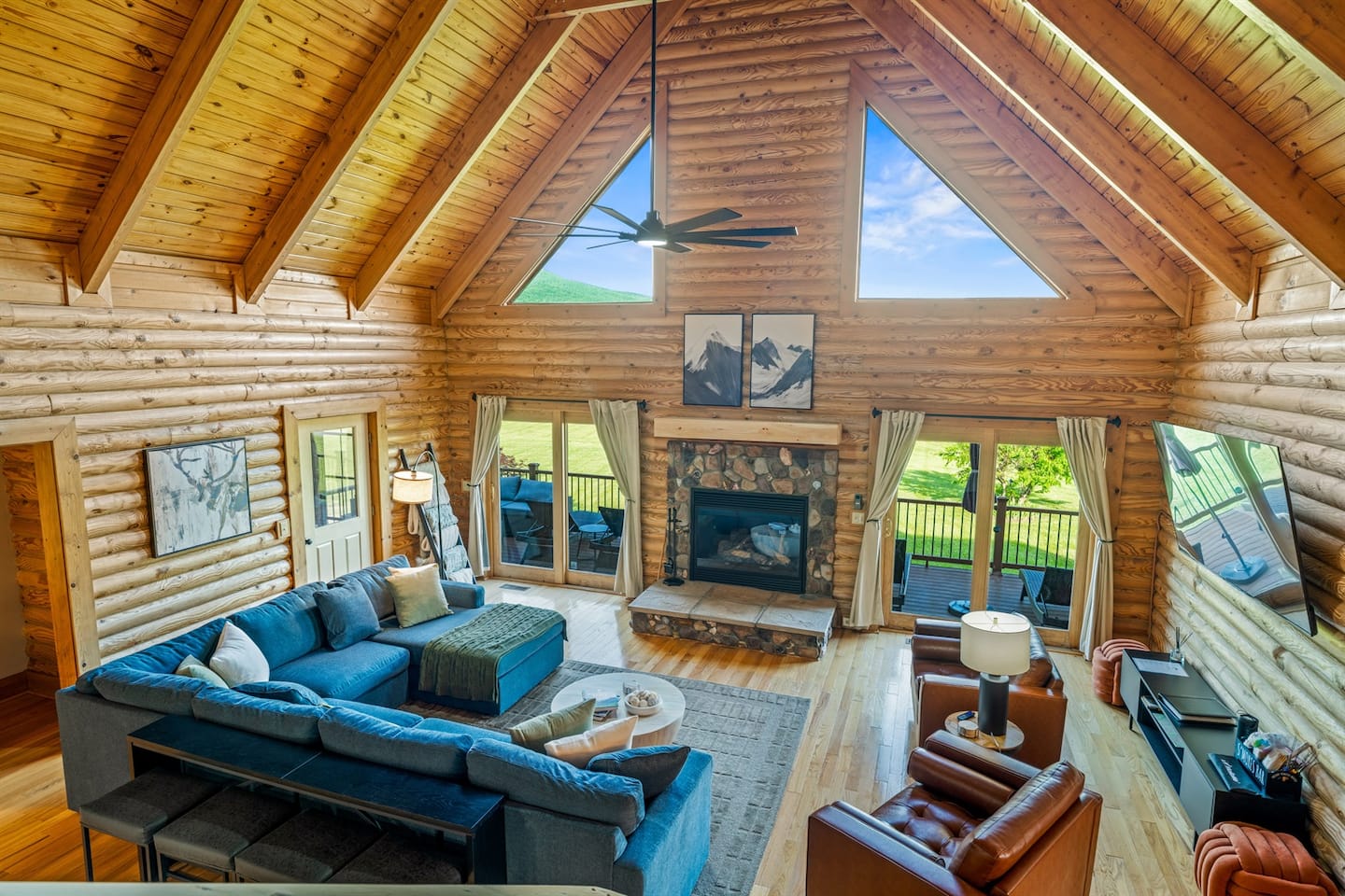 Wide-open living space with vaulted ceilings, deep blue sectionals, and unobstructed Shenandoah views.