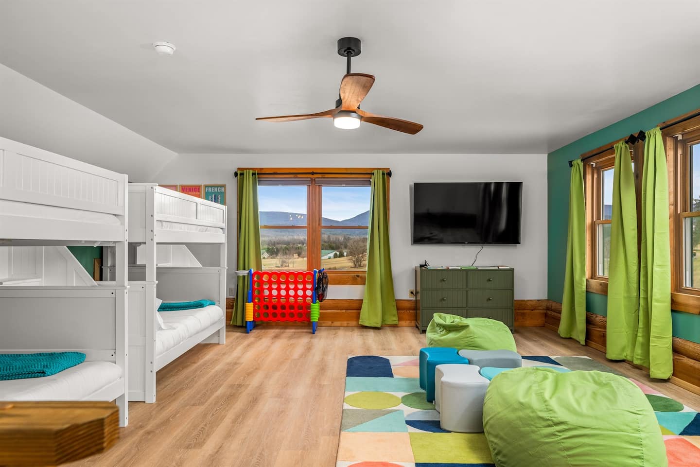 The kids' bunk room with two full bunk beds, a seating area, and a mountain view