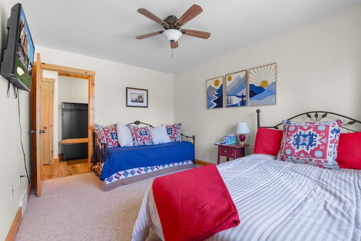 Bedroom 3 sits on the main floor and offers both a queen and twin bed—perfect for families or friends. A ceiling fan and TV make it an extra cozy spot to unwind.