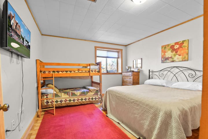 Bedroom 4 sits on the lower level and includes a TV, a king bed and two twin beds bunked.  Perfect for families or groups. It’s just steps from a full bathroom and all the basement fun.