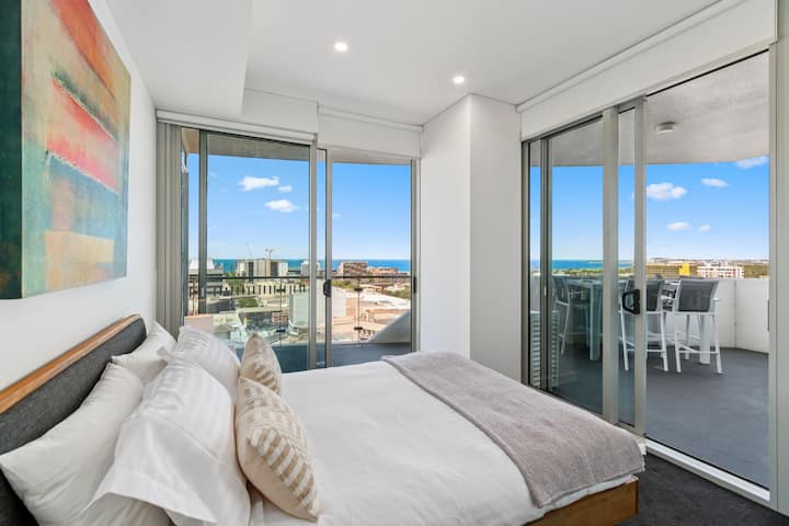 Retreat to the second bedroom with a plush queen bed, built-in wardrobe, and direct balcony access for serene morning views.