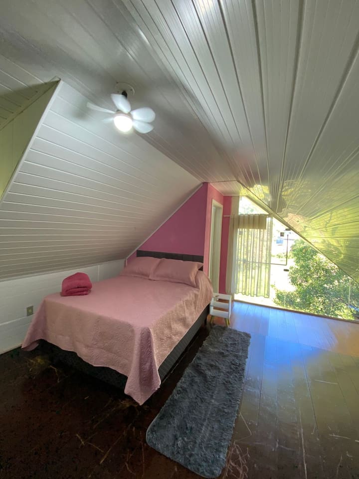 Segundo quarto no andar superior, uma suíte ampla com cama de casal, espaço para guardar roupas e janelas amplas que deixam o ambiente iluminado e confortável. Perfeito para quem busca  tranquilidade.