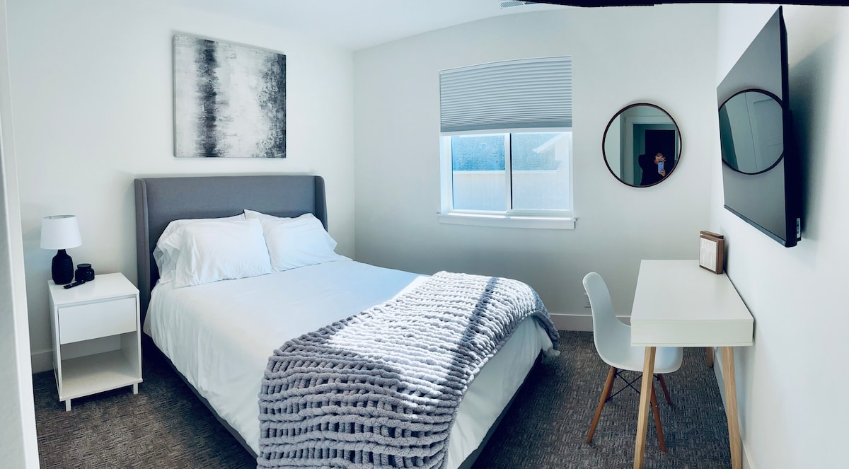 ฝันดีและทำงานได้ง่าย ห้องนอนนี้มีเตียงควีนไซส์ที่สบาย ทีวีติดผนัง และโต๊ะทำงานเฉพาะที่สะดวกสบาย