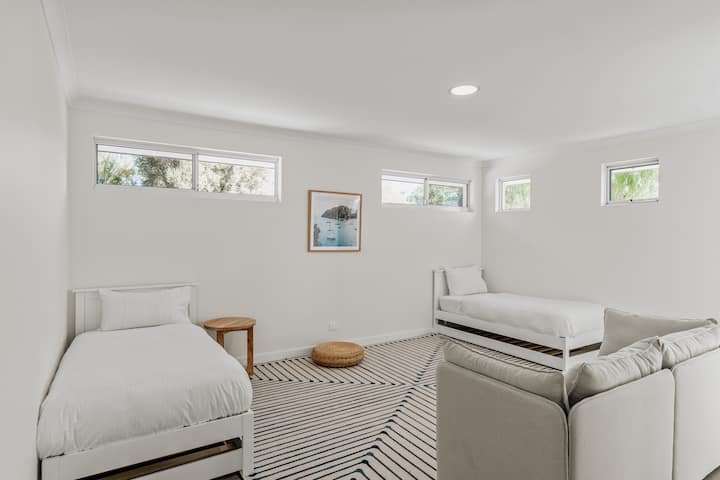 Tretia spálňa, navrhnutá s ohľadom na všestrannosť, ponúka dve samostatné postele s výsuvnými posteľami a pohodlnú rozkladaciu pohovku – ideálnu pre rodiny alebo priateľov, ktorí si užívajú pohodové dni na pobreží.