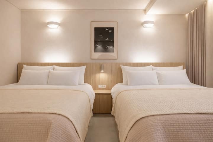 غرفة نوم بسريرين بحجم كوين،
مزيج من درجات الخشب الهادئة والإضاءة الدافئة
نحن نقدم راحة مريحة مثل الفندق.