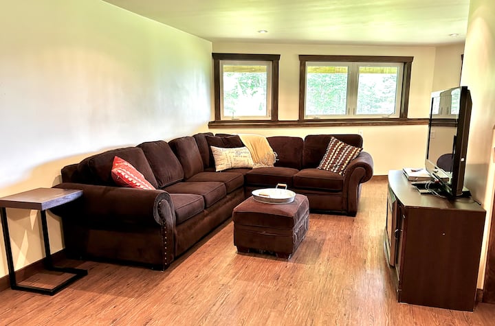Eneo la chini la kukaa lenye kitanda cha sofa cha Malkia kwa ajili ya makundi ya watu 8. Mfumo wa kupasha joto sakafuni wenye eneo la kukausha vifaa vya skidoo.