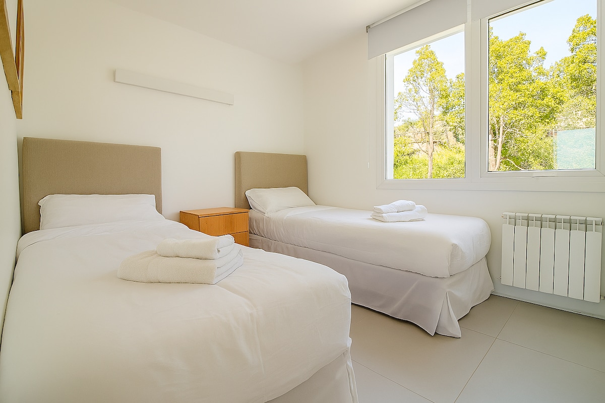 Habitación luminosa con dos cómodas camas individuales, que pueden hacerse como 1 cama doble.  Ideal para familias o grupos. Sus amplios ventanales ofrecen vistas al entorno natural, creando un ambiente relajante.