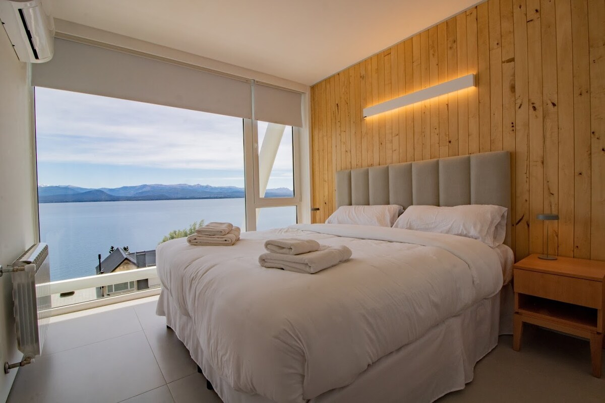 Habitación amplia y comoda, con una imponente vista panorámica al Lago gracias a sus ventanales de piso a techo. Cuenta con una cama grande o 2 camas simples según su preferencia. Ideal para descansar y despertar frente a un paisaje único.