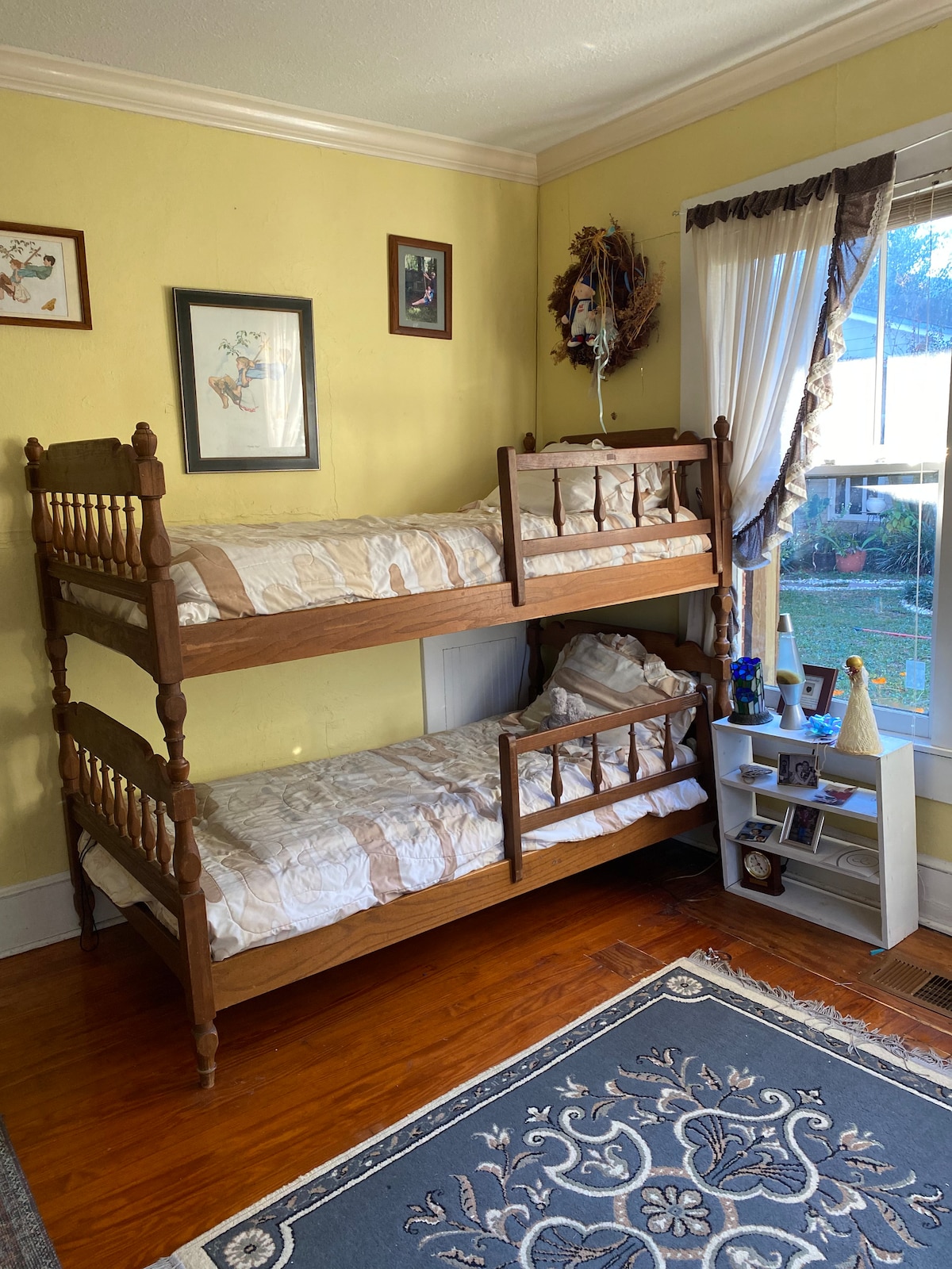 Chambre au rez-de-chaussée avec lits superposés et beaucoup de livres et de casse-têtes.