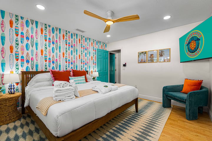 სერფინგის მოყვარულებისთვის განკუთვნილი საძინებელი. კაშკაშა კედელი, ხავერდოვანი თეთრეული და სანაპიროს სტილში მოწყობილი დეკორი ამ ოთახს დასასვენებლად იდეალურ ადგილად აქცევს.