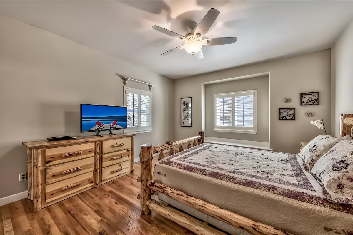 ห้องนอนลอดจ์แบบชนบทที่มีเฟอร์นิเจอร์ไม้และพื้นไม้เนื้อแข็ง เพลิดเพลินกับการเข้าพักที่สะดวกสบายและติดตามข่าวสารทางทีวี! 