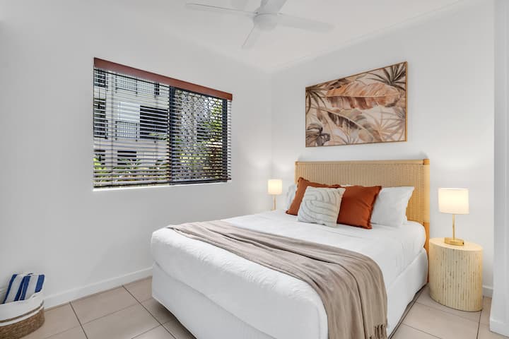 להירגע על מיטת הקווין סייז של הדירה הראשית עם מצעים לבנים וצחים, הסיום המושלם ליום שטוף שמש על החוף.