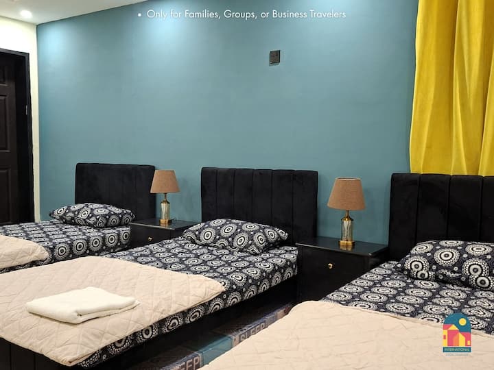 Dhomë gjumi e ndritshme me tre krevate tek dhe një banjë të bashkangjitur për më shumë rehati.