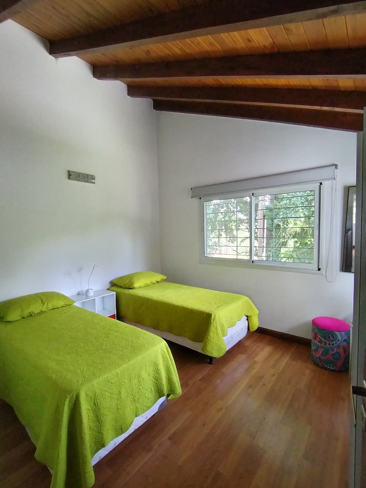 חדר אביזרים בקומה העליונה עם שתי מיטות יחיד. 