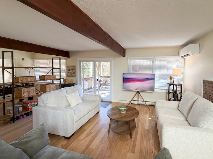 Living area on the ground floor with a TV, games, puzzles, and foosball table. The two white loveseats are twin pullouts. 