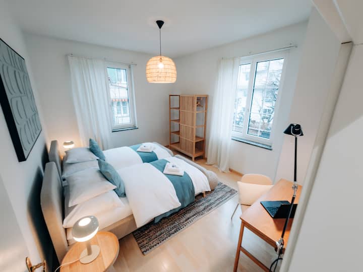 宽敞的卧室，配备工作站和酒店品质的床上用品和毛巾。