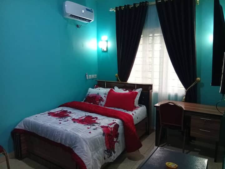 Dormitorio en suite equipado con aire acondicionado, TV inteligente con Netflix, ventilador, nevera, espejo, armario, reloj de pared y marco, mesa de lectura y sillas, etc. Electricidad 24/7 alimentada por inversor híbrido de 20 kva, generador de reserva y electricidad general.