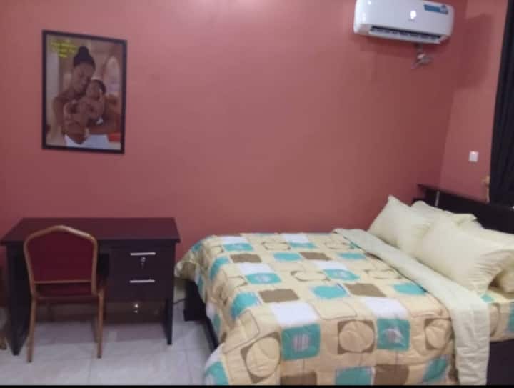 Dormitorio en suite equipado con aire acondicionado, TV inteligente con Netflix, ventilador, nevera, espejo, armario, reloj de pared y marco, mesa de lectura y sillas, etc. Electricidad 24/7 alimentada por inversor híbrido de 20 kva, generador de reserva y electricidad general.
